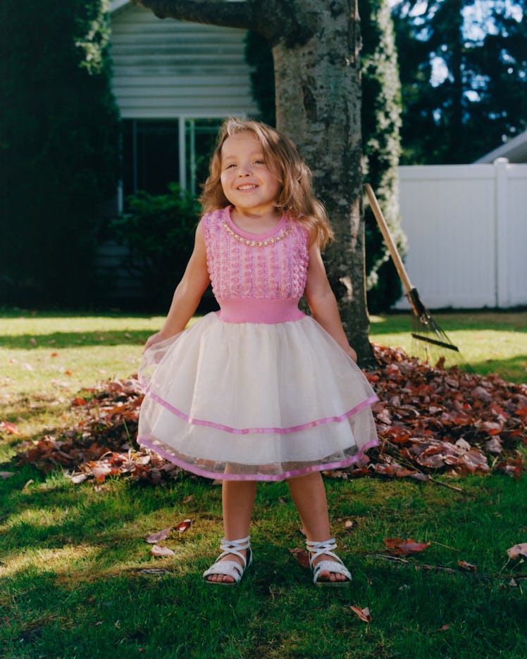 A happy girl in a pink vest and white-pink tutu standing and posing for Matthew So’s series, Picture...