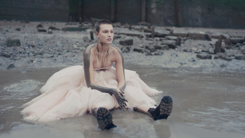 An Alexander McQueen model sitting in mud