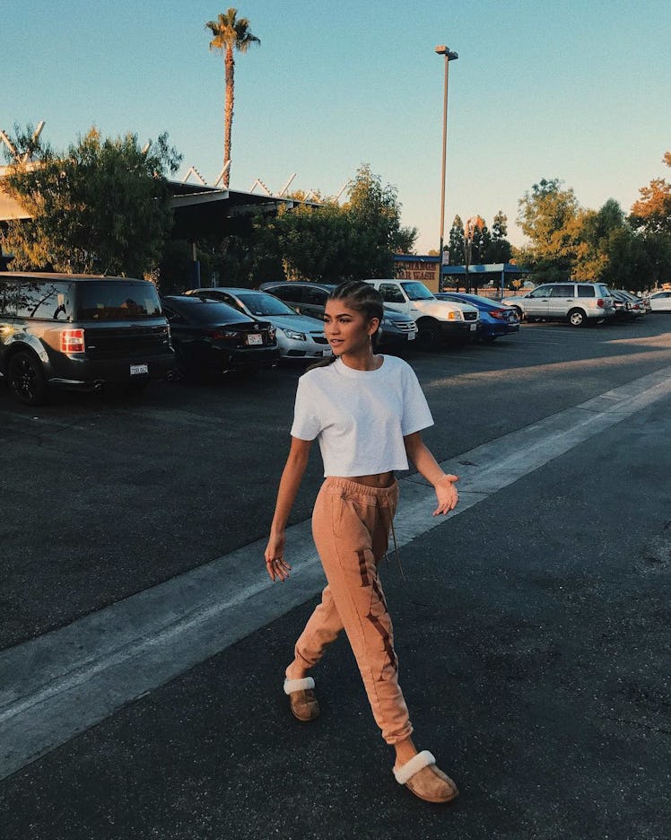 Zendaya passing a parking lot in sweatpants and Ugg Scuff slippers