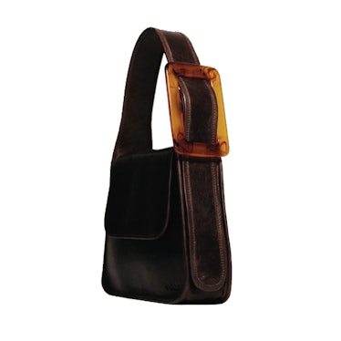 The Edas Yshaia Cowhide Leather Shoulder Bag in black, with a brown buckle on the side 