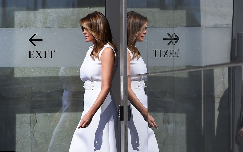 Melania Trump walks out a door.