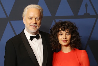 Tim Robins in a black suit, a white shirt and a black bow tie and Gratiela Brancusi in a red dress