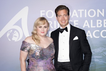 Rebel Wilson  in a silver off-the-shoulder dress and Jacob Busch in a black suit, white shirt and a ...