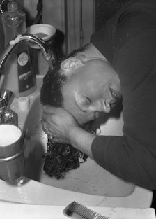 A woman washing her hair above a sink