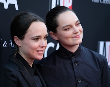 Elliot Page in a black blazer and shirt and Emma Portner in a black coat