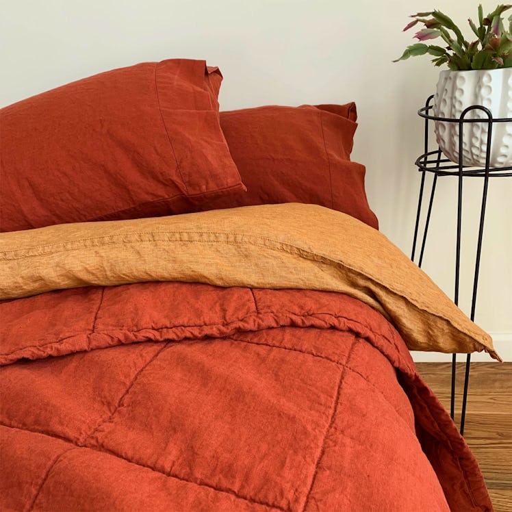 Linoto bedding with red pillows, a yellow blanket and a red throw 