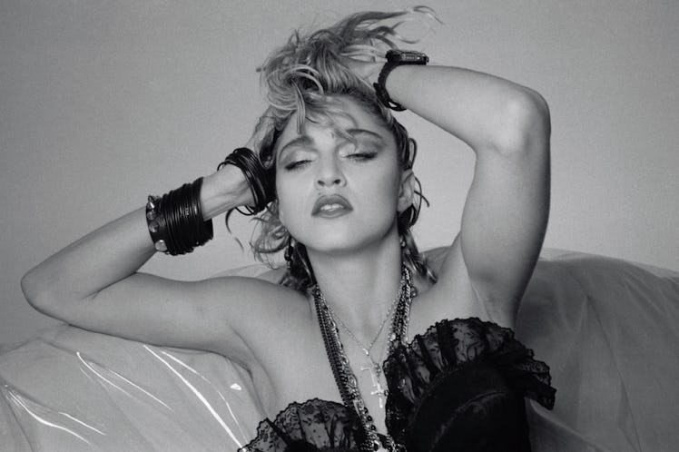 Madonna in a black top posing while holding her hair up during her ''Like a Virgin'' Era