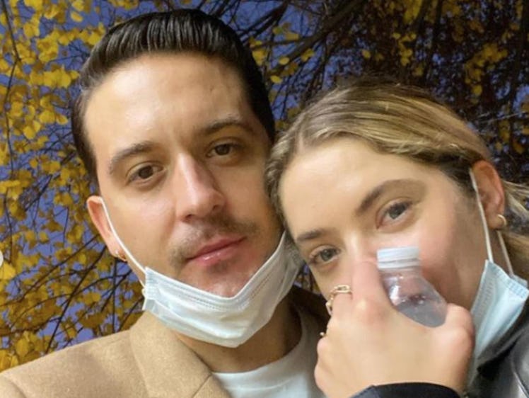 G-Eazy in a beige coat and Ashley Benson in a black jacket with white face masks