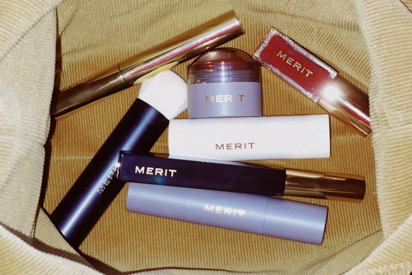 Seven All-in-One Beauty Products by Merit in a brown velvet bag
