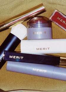 Seven All-in-One Beauty Products by Merit in a brown velvet bag