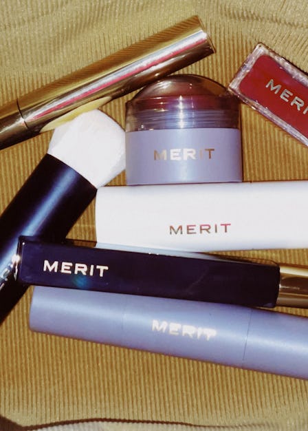 Seven All-in-One Beauty Products by Merit in a brown velvet bag