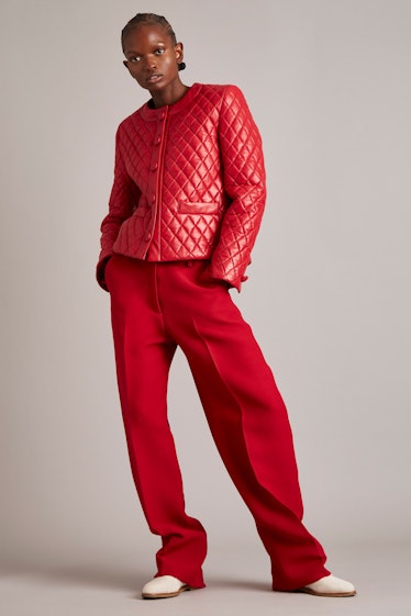 A model in a red coat and red pants by Adam Lippes
