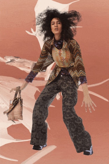 A model in a semi-sheer brown blouse and floral brown pants by Collina Strada