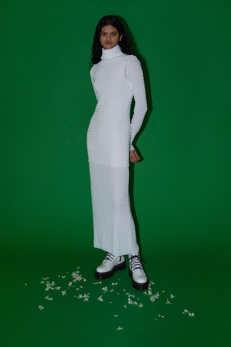 A model in tight, white, ankle-length dress by Rosetta Getty