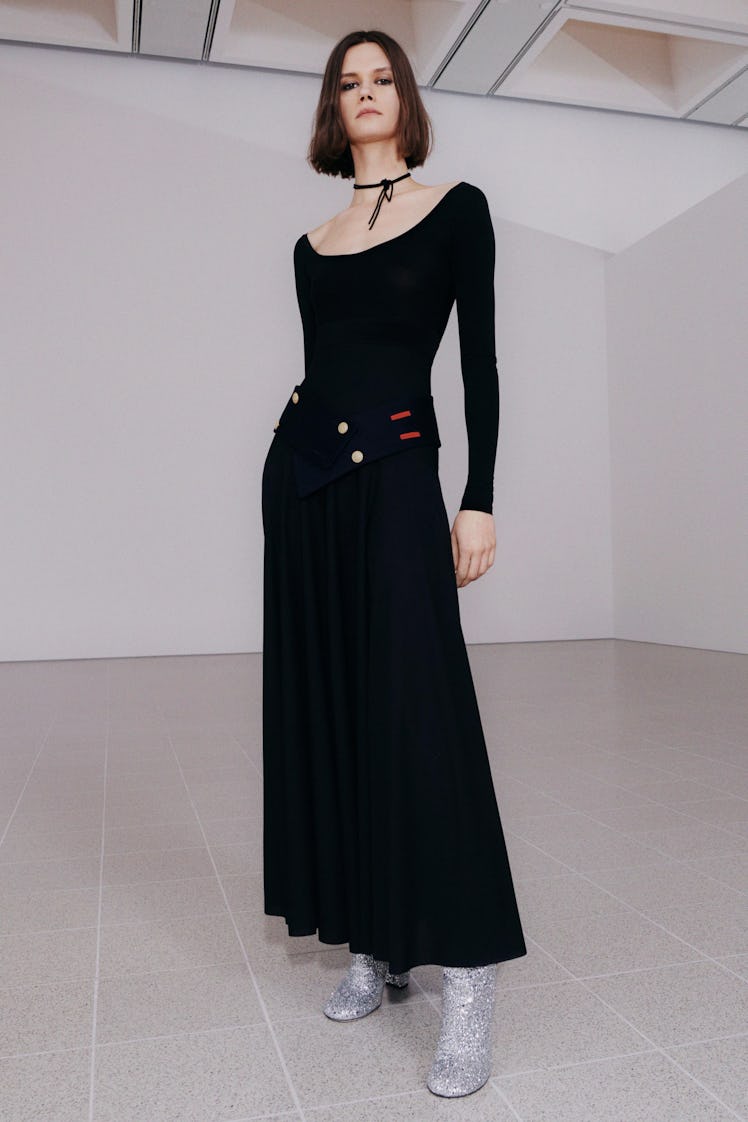 A model in a long black dress by Victoria Beckham