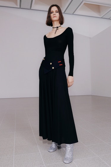 A model in a long black dress by Victoria Beckham