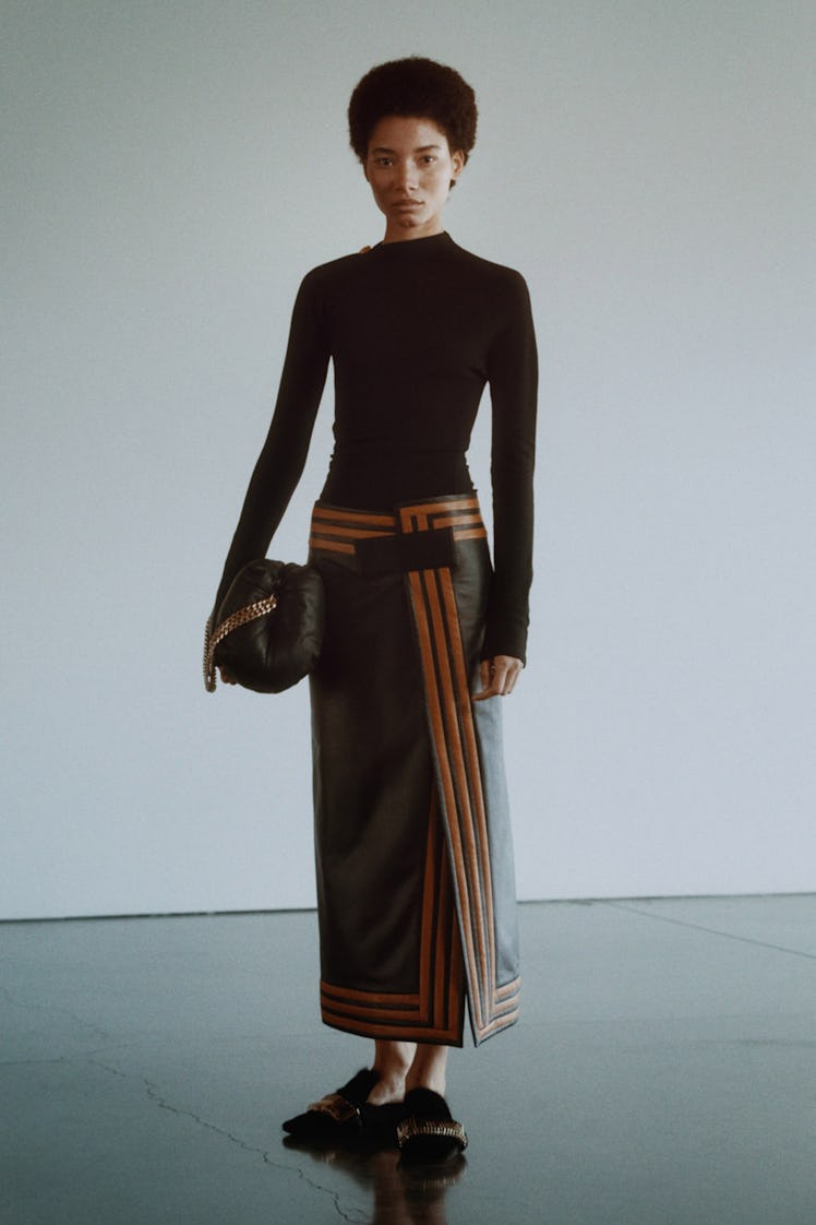 A model in a long-sleeved black sweater and leather skirt by Proenza Schouler