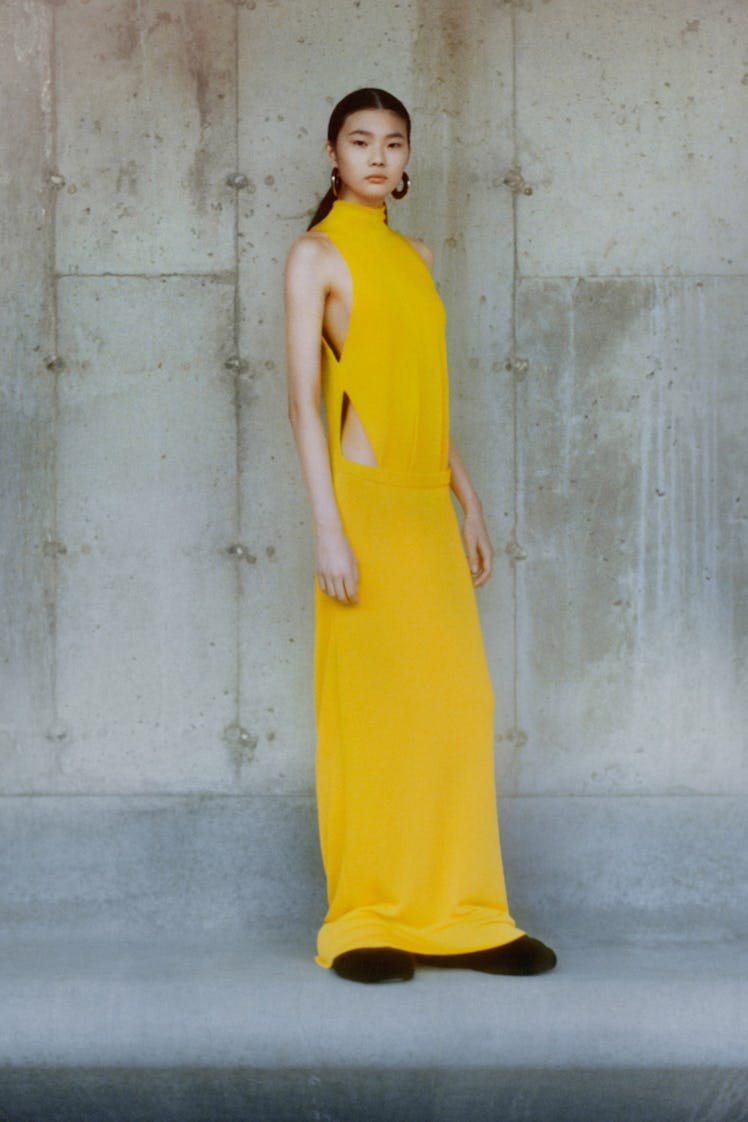 A model in a yellow long gown with cutouts on the sides by Proenza Schouler