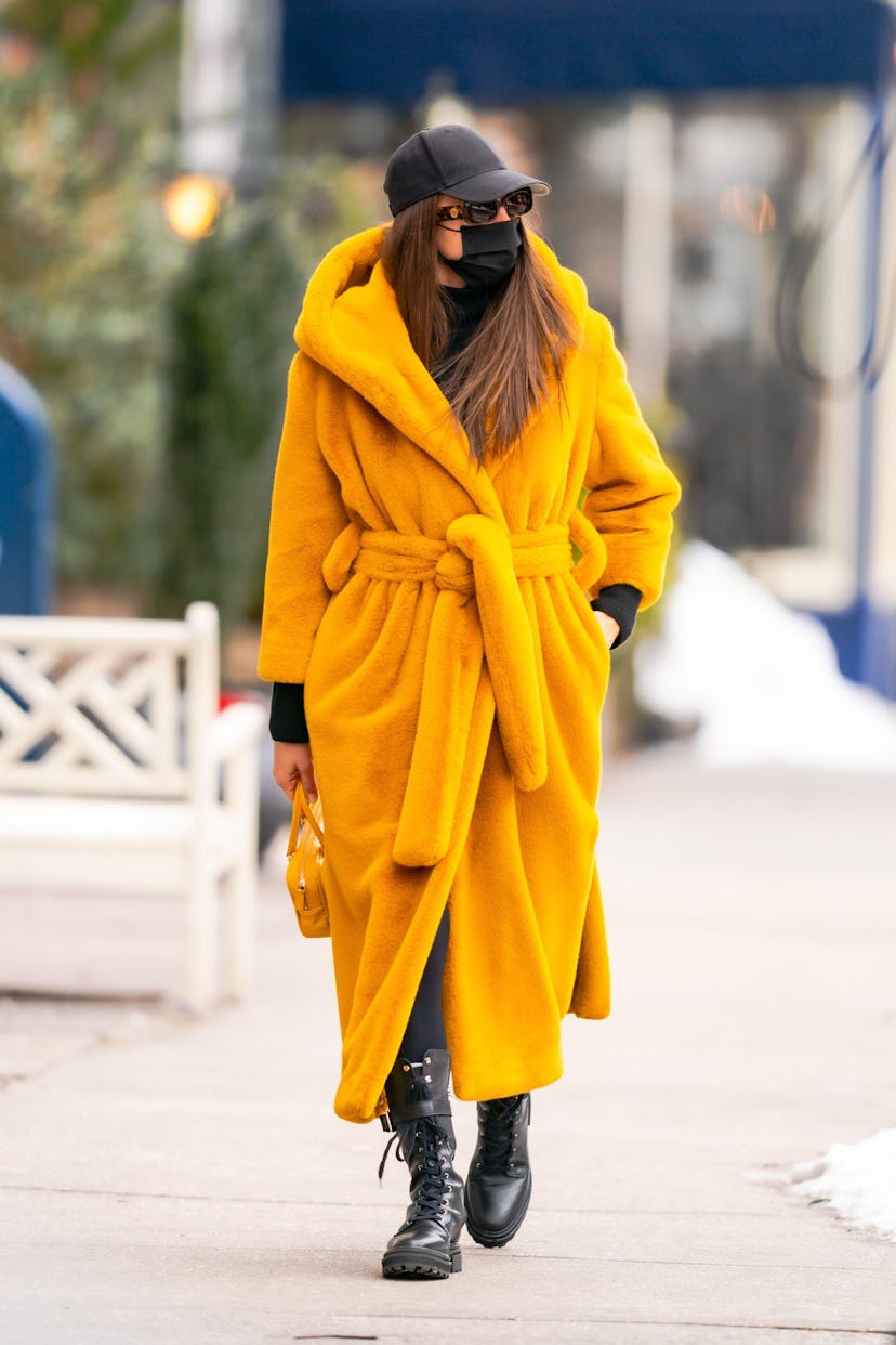 Irina Shayk walking in an orange coat