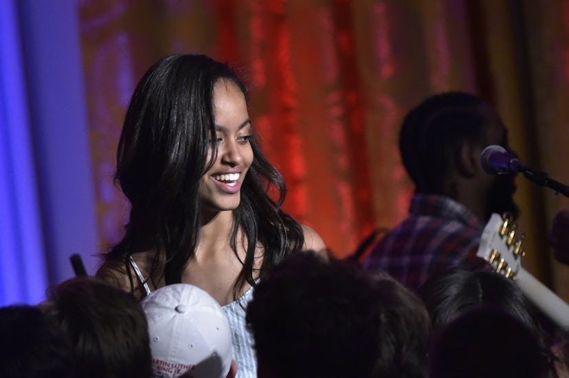 Malia Obama at an event smiling and looking to the side