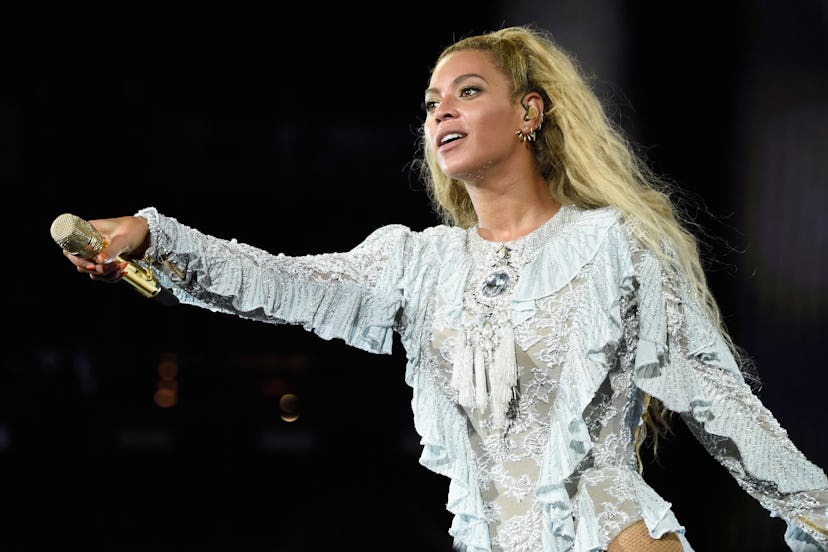 Beyoncé wearing a gray laced leotard and holding a microphone while performing at the Texas Storm Ai...