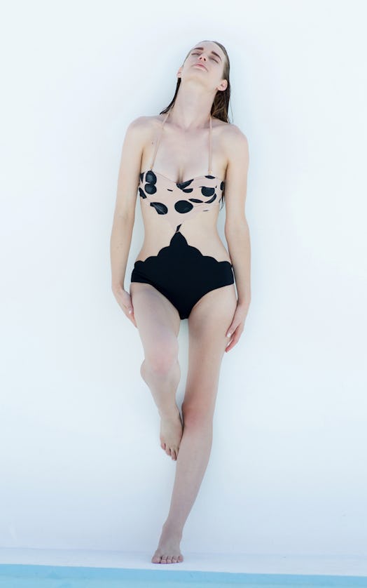A female model posing in a brown and black cut-out maillot
