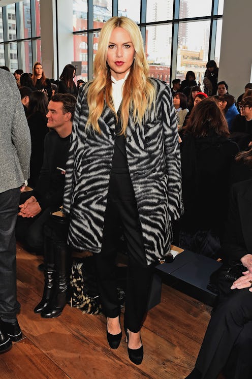 Rachel Zoe in a black-white animal print coat, black pants, and hoes at a fashion event