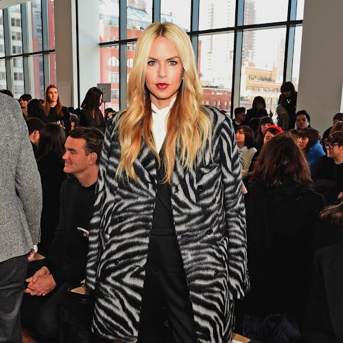 Rachel Zoe in a black-white animal print coat, black pants, and hoes at a fashion event