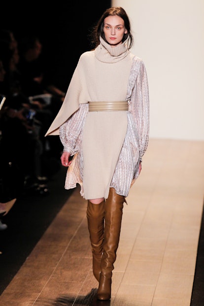 A model walking the runway in over-the-knee leather boots and BCBG Max Azria's split knits