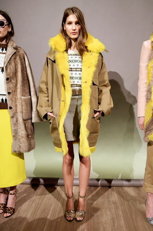 A model backstage posing in J.Crew's yellow shearling parka