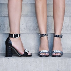 Closeup of two women's feet in black sandal heels