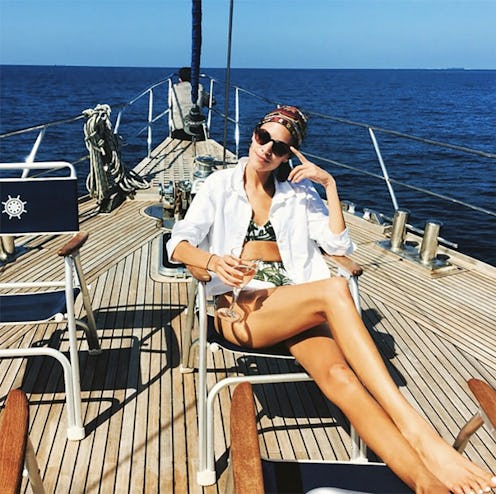 A model posing on a yacht in a white Endless Shirt J.Crew as a cover-up for her swimsuit