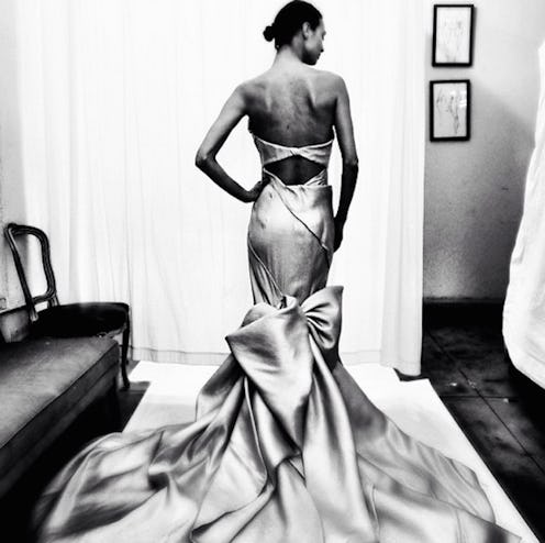 A model posing in Donna Karan's long gown with a cut-out back