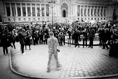 Strike A Pose street-style photographer standing in front of a large crowd of people in black and wh...