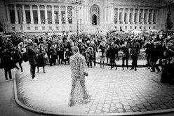 Strike A Pose street-style photographer standing in front of a large crowd of people in black and wh...