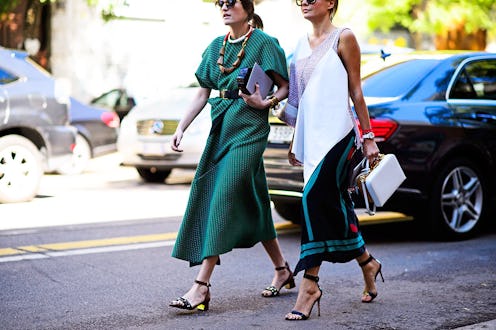 Two ladies walking in green and white street-style dresses from the Milano Fashion Week