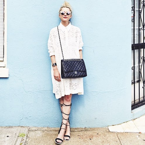 A cool girl in a white lace dress, wearing a black Chanel bag, and black sandals