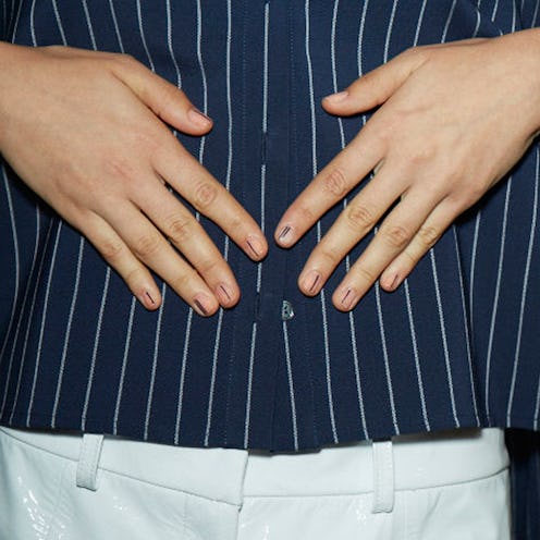 A closeup of hands with easy-to-do nail art consisting of one line at the center of every nail