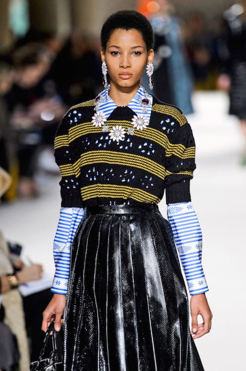 Lineisy Montero walking the runway in a striped sweater, collared shirt and black leather skirt