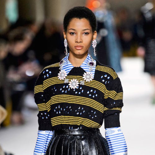 Lineisy Montero  walking the runway in a striped sweater, collared shirt and black leather skirt