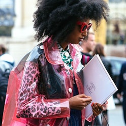 A woman in a leopard print leather jacket with a raincoat over it