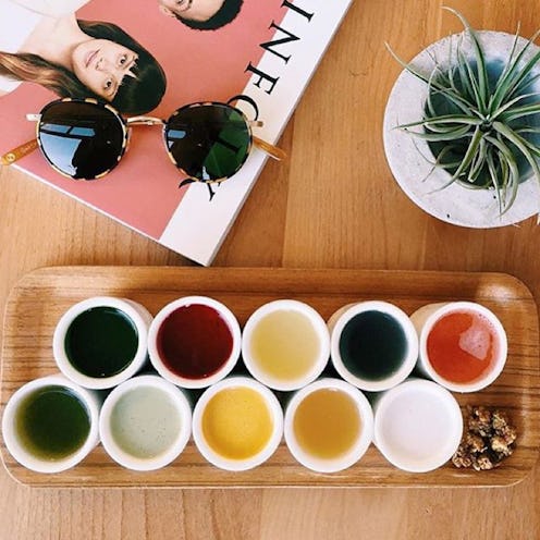 10 small cups with tea on a wooden plate as way to cleanse post-holiday