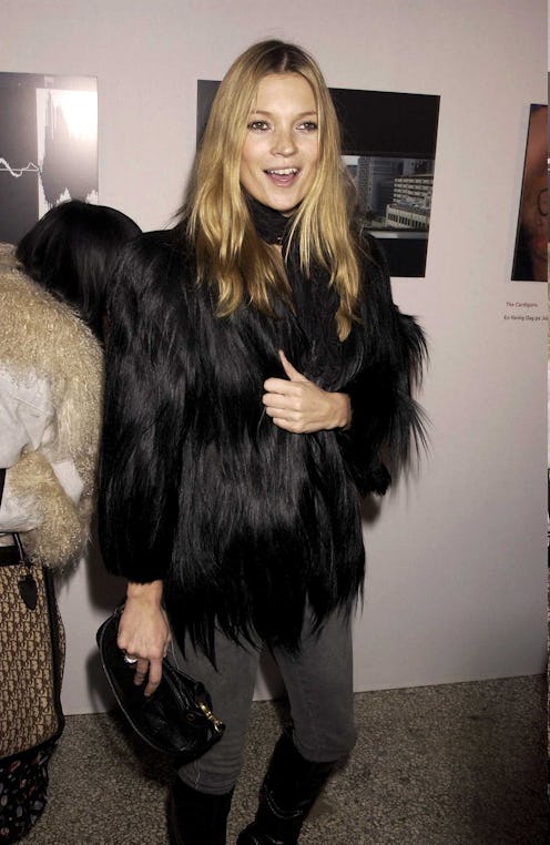 A woman in a faux fur coat, with a black handbag at her office party