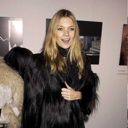 A woman in a faux fur coat, with a black handbag at her office party 