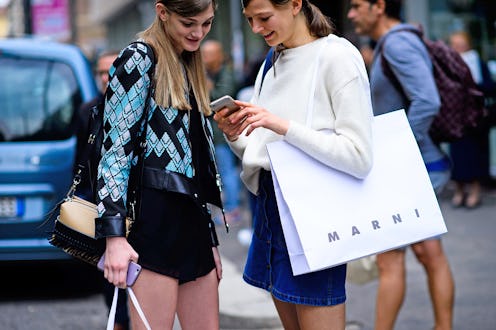 Two women with shopping bags on the street during Black Friday