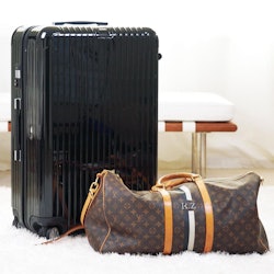 Packed black suitcase next to the Louis Vuitton travel bag
