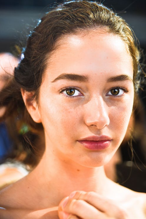 A brunette model's close-up portrait in the morning before going to the runway