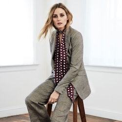 Olivia Palermo in a grey suit with a burgundy-white polka-dot scarf