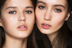 Two women with thier faces touching look at the camera after using cleansing water