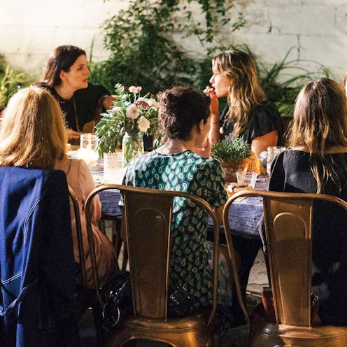 A lot of female friends sitting at a table and having dinner together